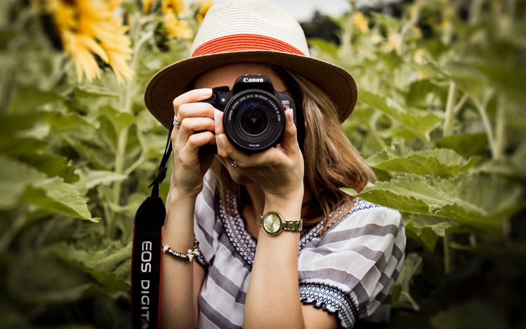 selective focus photography of woman holding dslr camera
