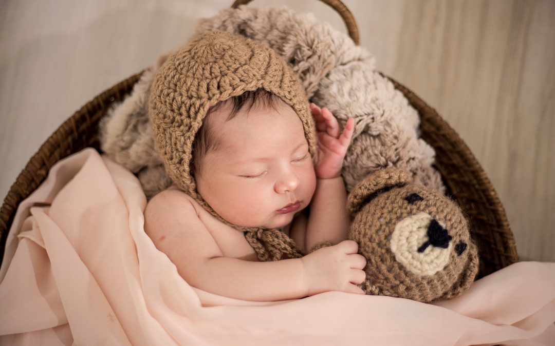 baby wearing brown knit cap while sleeping